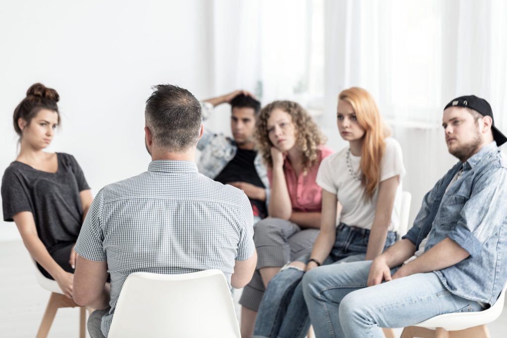Group of young people talking to a psychologist in a rehab center